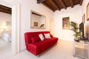 a red couch in a living room with a mirror at Intero Appartamento AnticaValle in Verona