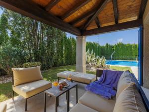 une terrasse avec un canapé et des chaises ainsi qu'une piscine dans l'établissement Villa Feniks by Interhome, à Višnjan