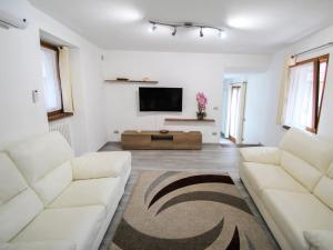 Il comprend un salon doté d'un mobilier blanc et d'une télévision à écran plat. dans l'établissement Apartment Elsa by Interhome, à Dumenza