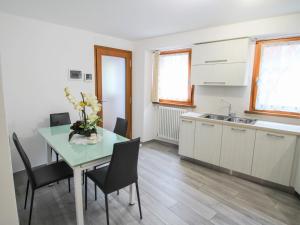 a kitchen with a table and chairs and a sink at Apartment Elsa by Interhome in Dumenza +11 photos