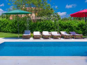a group of chairs and umbrellas next to a pool at Villa Bella by Interhome in Marčana +39 photos