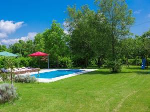 a swimming pool in a yard with chairs and umbrellas at Villa Bella by Interhome in Marčana