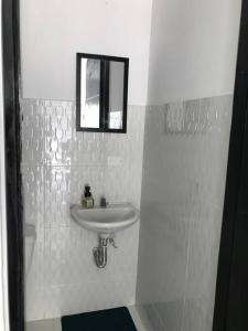 a white bathroom with a sink and a mirror at Rest 1 in Santa Marta