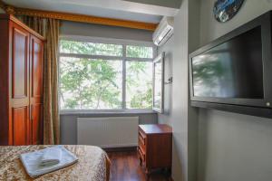 een kamer met een bed, een raam en een televisie bij Californiacityhotel in Istanbul