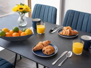 a table with plates of food and orange juice at Studio Harbour Nights 12 Deluxe by Interhome in Lossiemouth