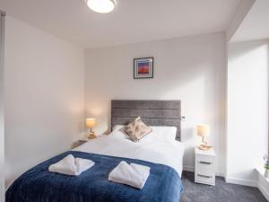 een slaapkamer met een groot bed en 2 lampen bij Apartment Harbour Nights 12 Deluxe by Interhome in Lossiemouth
