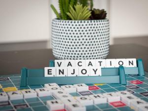 a keyboard with the words vacation enjoy sitting next to a vase at Studio Harbour Nights 12 Deluxe by Interhome in Lossiemouth