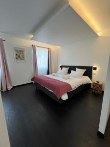 a bedroom with a large bed with a red blanket at Hôtel Restaurant & Spa du Tremplin in Bussang