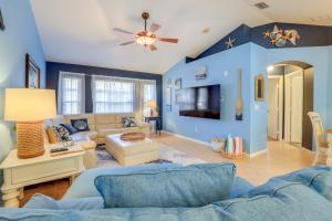 un soggiorno con pareti blu e divano di Jensen Beach Home with Heated Pool! a Jensen Beach