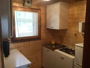 a small kitchen with a stove and a window at Chalet Natura Sport&Relax in Cavaliere