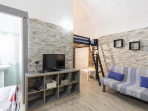 a living room with a tv and a brick wall at Holiday Home Kicca by Interhome in Sanremo
