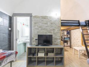 a living room with a tv and a brick wall at Holiday Home Kicca by Interhome in Sanremo
