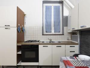 a kitchen with white cabinets and a sink and a window at Holiday Home Kicca by Interhome in Sanremo +15 photos