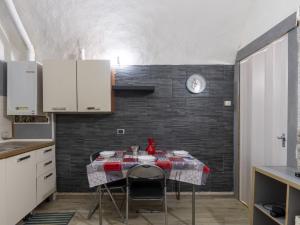 a kitchen with a table with chairs and a clock on a wall at Holiday Home Kicca by Interhome in Sanremo