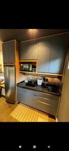 uma cozinha com armários de aço inoxidável e um frigorífico em Carpe Diem Cabanas 2 em Campo Largo