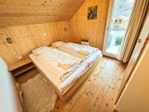 a bed in a wooden room with a window at Kreischberg 14b in Sankt Lorenzen ob Murau