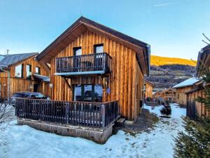 a log cabin with a balcony and snow on the ground at Kreischberg 14b in Sankt Lorenzen ob Murau