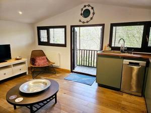 a kitchen with a sink and a table in a room at Treetops Lodge, private parking & garden in Truro