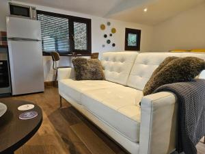 a living room with a white couch and a table at Treetops Lodge, private parking & garden in Truro