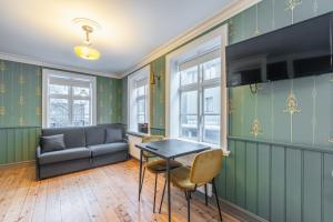 un soggiorno con pareti verdi, tavolo e sedie di Day Dream Historical Grjótagata 4 a Reykjavik
