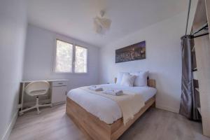 1 dormitorio con cama con sábanas blancas y escritorio en Trioasis - 3 chambres, en Reims