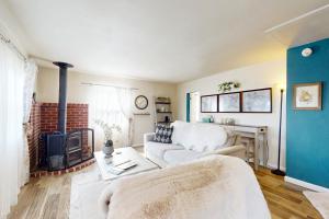 a living room with a white couch and a fireplace at Bella Bella Beach Cottage in Gig Harbor