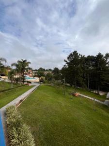 a park with green grass and trees and a road at Recanto Paraíso Aventuras in Rio Negrinho