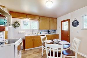 eine Küche mit einem Tisch und Stühlen in einer Küche in der Unterkunft Bella Bella Beach Cottage in Gig Harbor