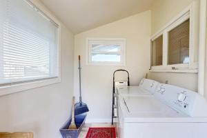 eine weiße Waschküche mit 2 Waschbecken und einem Fenster in der Unterkunft Bella Bella Beach Cottage in Gig Harbor + 22 Fotos