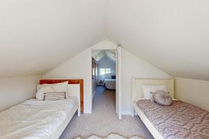 a attic bedroom with two beds and a mirror at Bella Bella Beach Cottage in Gig Harbor