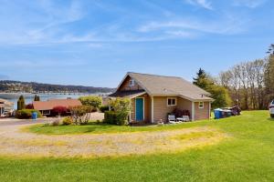 a house on a lawn with a view of the water at Bella Bella Beach Cottage in Gig Harbor