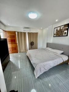 1 dormitorio con 1 cama y TV de pantalla plana en Sierra Bay View 3-BR Jacuzzi Overlooking Roofdeck, en Binangonan