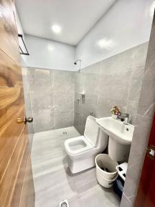ein Bad mit einem WC und einem Waschbecken in der Unterkunft Sierra Bay View 3-BR Jacuzzi Overlooking Roofdeck in Binangonan