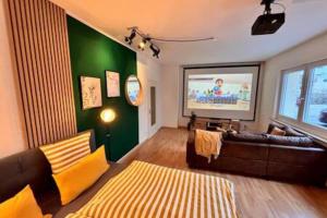 a living room with a couch and a flat screen tv at Modern & Stilvoll mit Kino - Wii in Essen
