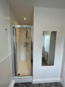 a bathroom with a shower with a mirror at Seaham Sea View 2 bedroom apartment in Seaham