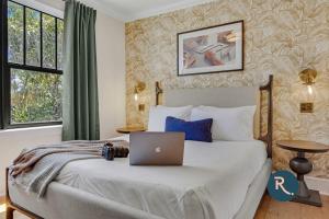 1 dormitorio con 1 cama con ordenador portátil en Roami at Tower Hotel - Calle Ocho, en Miami