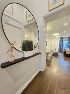 a large round mirror on a wall in a living room at Delightful 2 Bedroom Apartment! in London