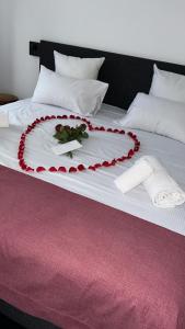 una cama decorada con flores rojas. en Hôtel Restaurant & Spa du Tremplin, en Bussang