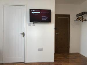 um quarto com uma porta branca e uma televisão na parede em Studio in Bolton town, Short stay studio 5, em Bolton