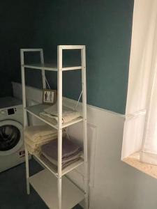 una mensola bianca in una stanza con lavatrice di Casa di Andre a Cerveteri