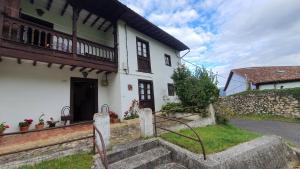 a white house with stairs in front of it at Vivienda Vacacional Casa Casenti in Villanueva de Ardisana