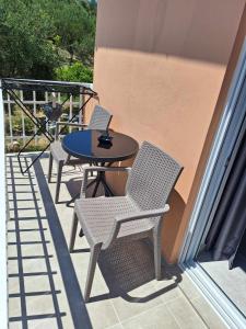 a patio with three chairs and a table on a balcony at Two Brothers Studios Tsilivi Zakynthos in Tsilivi