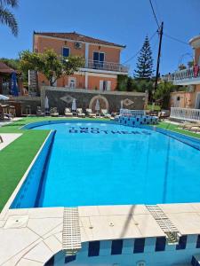 a large swimming pool in front of a house at Two Brothers Studios Tsilivi Zakynthos in Tsilivi