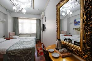 een hotelkamer met 2 bedden en een spiegel bij Californiacityhotel in Istanbul