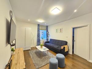 a living room with a couch and a table at Delightful 2 Bedroom Apartment! in London