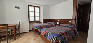 斯科佩洛的住宿－阿爾坎圖茲歐酒店，客房设有两张床、一张桌子和一扇窗户。