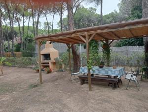 a picnic table under a pavilion in a garden at Casa Helichrysum in Forte Village