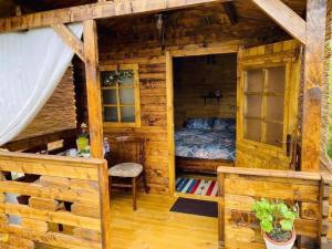 - une chambre avec un lit dans une maison en bois dans l'établissement Camping Mala Clisura Dunării, à Eşelniţa
