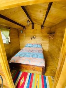 a bed in a small room in a wooden cabin at Camping Mala Clisura Dunării in Eşelniţa