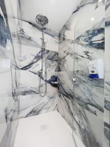 a bathroom with a shower with marble walls at Hotel Noguera El Albir in Albir